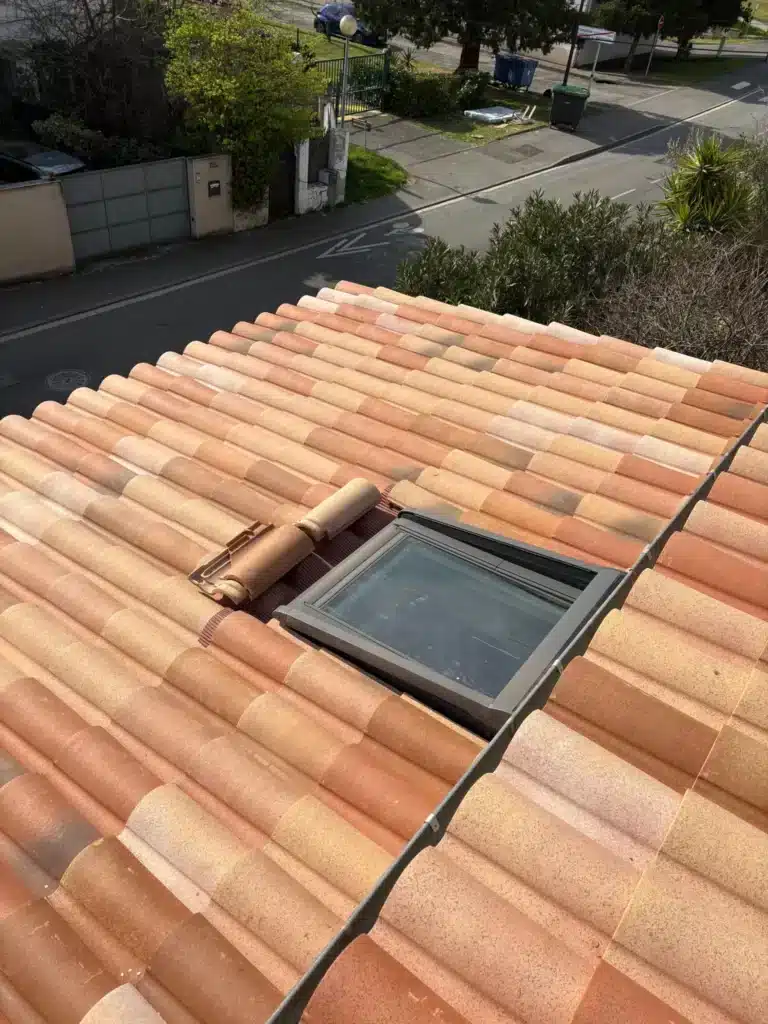 Rénovation de toiture à Auterive, vue du toit avec les tuiles posées et un ciel dégagé.